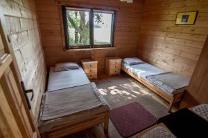 a room with two beds in a wooden cabin at Domek Mikołajki in Mikołajki