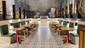 comedor con mesas y sillas en un suelo de baldosa en Joya Hotel, en Phnom Penh