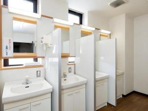 a bathroom with two sinks and two mirrors at New Biwako Hotel in Zeze-Awazumachi +135 photos