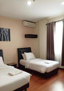 a hotel room with two beds and a window at Hotel Seri Pauh in Jalan Baharu