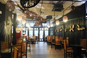 une salle à manger avec tables et chaises et un lustre dans l'établissement The Happy 8 Retreat @ Kuala Sepetang, à Kampung Sepetang