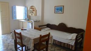 a bedroom with a bed and a table and chairs at Vocamvilia Apartments in Kamari