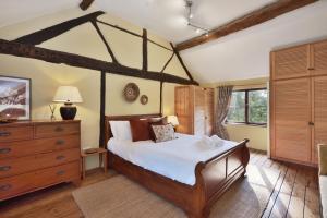 a bedroom with a canopy bed and a wooden dresser at Historic Farmhouse Idyllic Pets Nr Bromyard in Pencombe