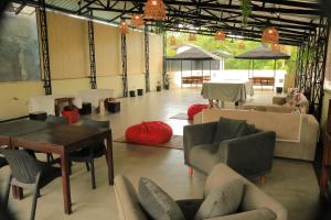 a living room with couches and a table and chairs at JJ's Hostel Mirissa in Mirissa
