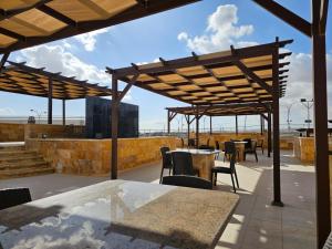 a patio with tables and chairs on a roof at النزل الفندقي مدينة الأمير هاشم بن عبدالله الثاني للشباب in Dulaylat al Ḩamāʼidah