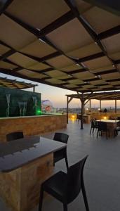 a patio with a table and chairs and a television at النزل الفندقي مدينة الأمير هاشم بن عبدالله الثاني للشباب in Dulaylat al Ḩamāʼidah