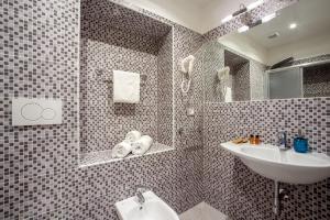 y baño con lavabo y espejo. en Frattina Grand Suite Guesthouse, en Roma