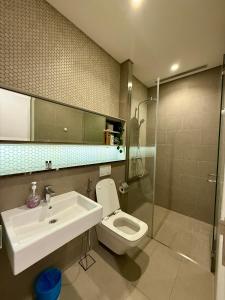 ein Badezimmer mit Waschbecken, Toilette und Spiegel in der Unterkunft Lucentia Residence by global stay in Kuala Lumpur