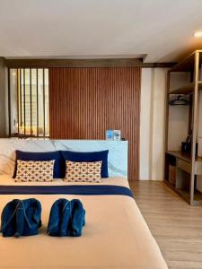 a bedroom with a large bed with blue pillows at Calm Kamala Phuket in Kamala Beach