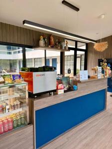 a store with a blue counter with food on it at Calm Kamala Phuket in Kamala Beach