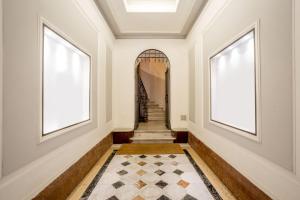 pasillo con escalera, 2 ventanas y alfombra en Frattina Grand Suite Guesthouse, en Roma