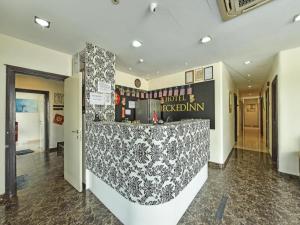 un hall d'un hôtel avec un comptoir de réception dans l'établissement Hotel CheckedInn, à Kampong Kuala Punti