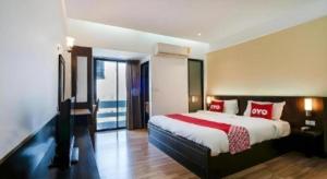 um quarto com uma cama grande com travesseiros vermelhos em Next Bird Suite em Banguecoque