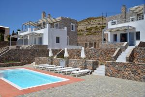 a villa with a swimming pool and a house at Ammothines in Xerokampos