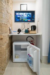 a tv sitting on top of a white table with a refrigerator at Vivarum b&b in Bitonto