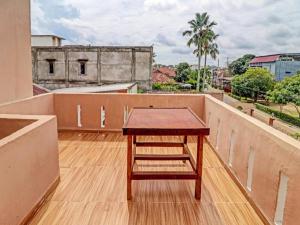 a wooden table on the roof of a building at OYO 90945 Arizon Kost in Jambi