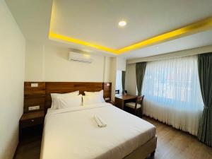 パタンにあるNavaya Residenceの大きなベッドと窓のあるホテルの部屋