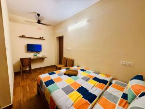 a bedroom with a bed and a desk in it at Citynest Residency in Pondicherry