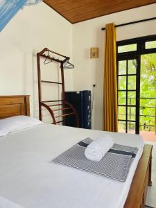 a bedroom with a bed with two towels on it at Ceylon Waves Weligama in Weligama