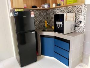 a toy kitchen with a black refrigerator and a sink at Iskandar SmartStay in Kampong Bota Road