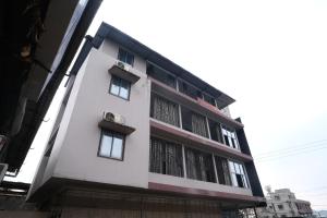 a white building with windows on the side of it at Shiva Guest House in Guwahati