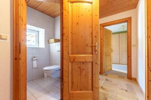 Un baño con inodoro y puerta de madera. en Jägerstube Preinfalk,  11 fotos más