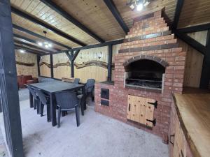 a patio with a brick fireplace with a table and chairs at Cabana Sofia in Burzeşti