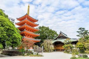 a large orange pagoda in front of a building at ライフモア春吉 in Wada