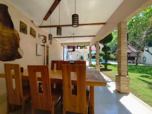 a dining room with a wooden table and chairs at Loox Cozy Villa in Kalijaga