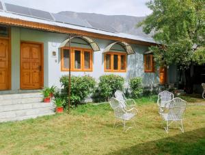 ein Haus mit Stühlen davor in der Unterkunft Serene in Gilgit