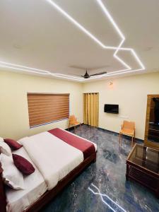 WayanadにあるJosebas Inn Vythiriのベッドと薄型テレビのある寝室