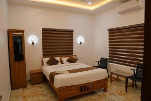 WayanadにあるJosebas Inn Vythiriの木製のヘッドボードが付いた大きなベッドのある寝室