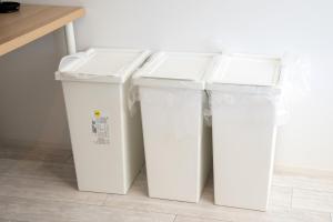 three white trash cans sitting next to a counter at シャングリラ沖縄 in Motobu