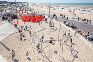 a group of people playing on a playground on the beach at Front de Mer in Calais