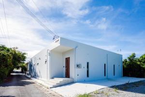 a white building with stairs on a street at シャングリラ沖縄 in Motobu