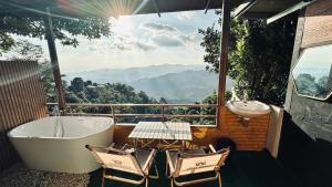 a bathroom with a bath tub and a table and chairs at Akimebonphuresort in Ban San Pu Loei (2)