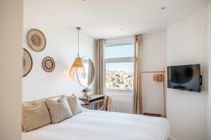 a bedroom with a white bed and a window at Harbour View House in St Ives