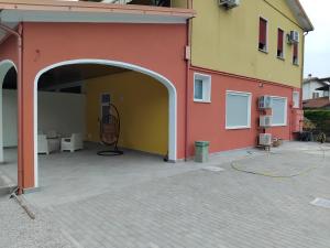 a building with an open garage with a hose attached at La Tavernetta delle Terme Euganee in Montegrotto Terme