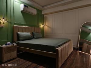 a bedroom with a bed in a green room at Luxury, Modern & Central Apartment Islamabad, with Gym, Near Motorway & Airport in Islamabad