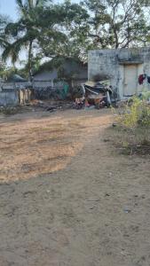 a house with a yard with a dirt field at Rainbow Guest House in Mahabalipuram