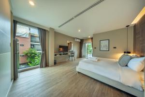 Un dormitorio con una gran cama blanca y una gran ventana. en Ralph Poshtel Pratunam, en Bangkok 61 fotos más