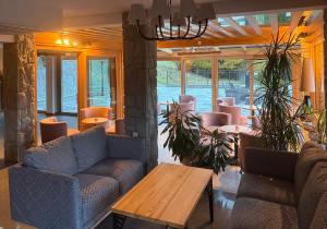 a restaurant with couches and a table and chairs at Bella Monte in Szczyrk