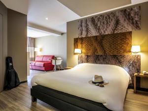 une chambre d'hôtel avec un lit avec un chapeau dessus dans l'établissement ibis Nuits Saint Georges, à Nuits-Saint-Georges 51 autres photos