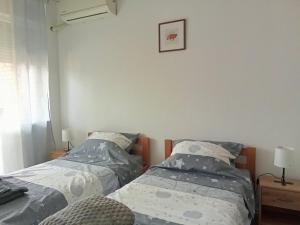two beds in a room with two lamps at Aleksej in Irig