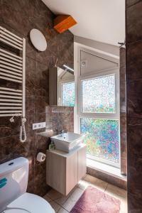 a bathroom with a sink and a window at Kotedžai GULBĖS TAKAS Šventojoje in Šventoji