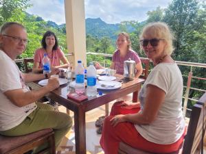 a group of people sitting around a table at Riva palace Homestay Rewalsar Lake in Malther