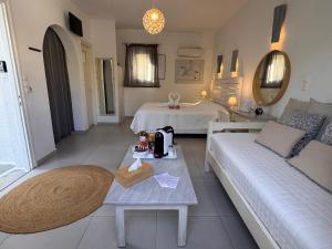 Una sala de estar con dos camas y un sofá en Diplos Studios, en Parikia