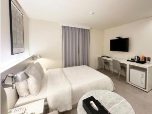 a hotel room with a bed and a desk at Sintra Hotel in Goyang