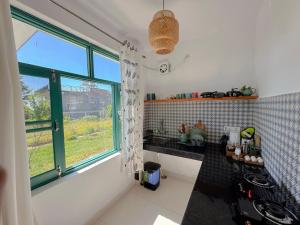 eine Küche mit Spüle und Fenster in der Unterkunft Cottage Story Bir in Bir