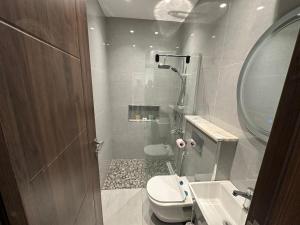 a bathroom with a toilet and a sink and a mirror at Masaken Hotel Apartment in Amman +62 photos